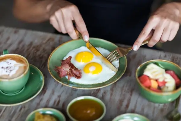 depositphotos 104825986 stock photo woman cutting fried eggs with