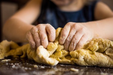 childrens-hands-knead-the-dough